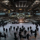 UNSC soldiers run through a military hangar filled with Pelicans and Warthogs, carrying gear.